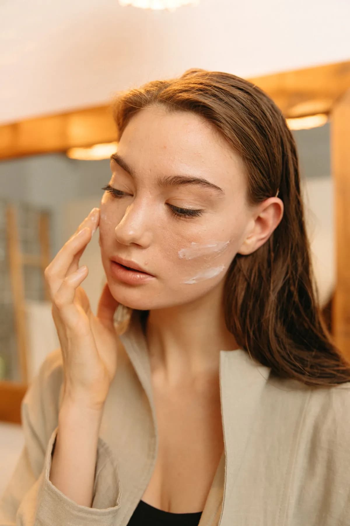 A woman resting her fingertips against her cheek