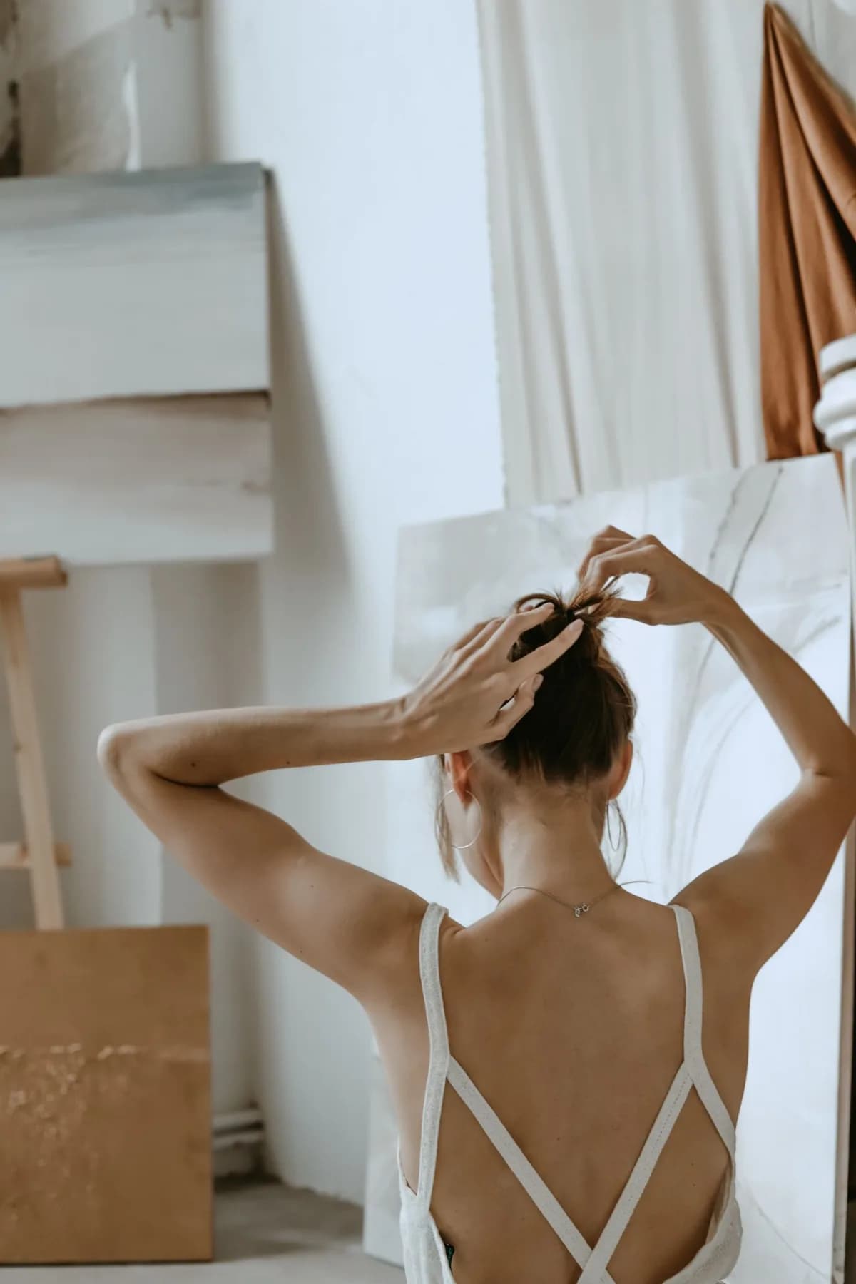 A woman seen from behind, gathering her hair